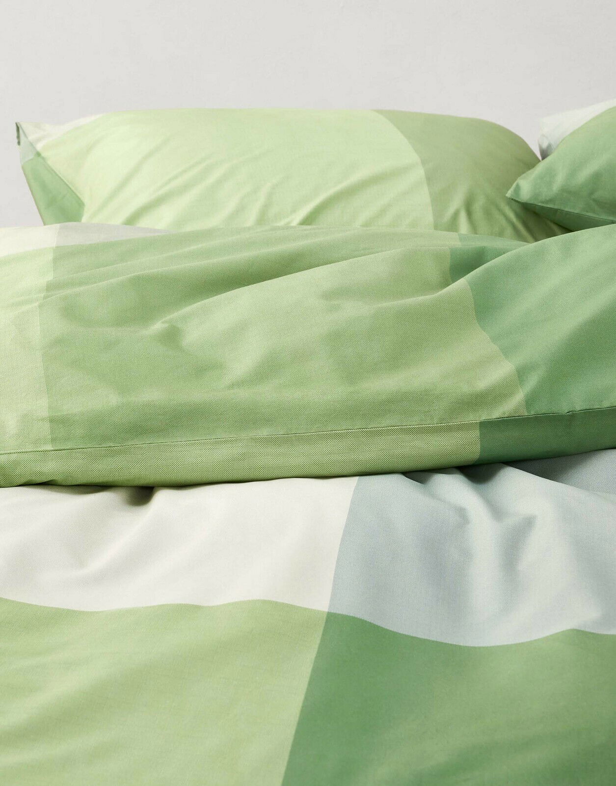 Grüne Bettwäsche mit geometrischem Muster, Nahaufnahme von oben