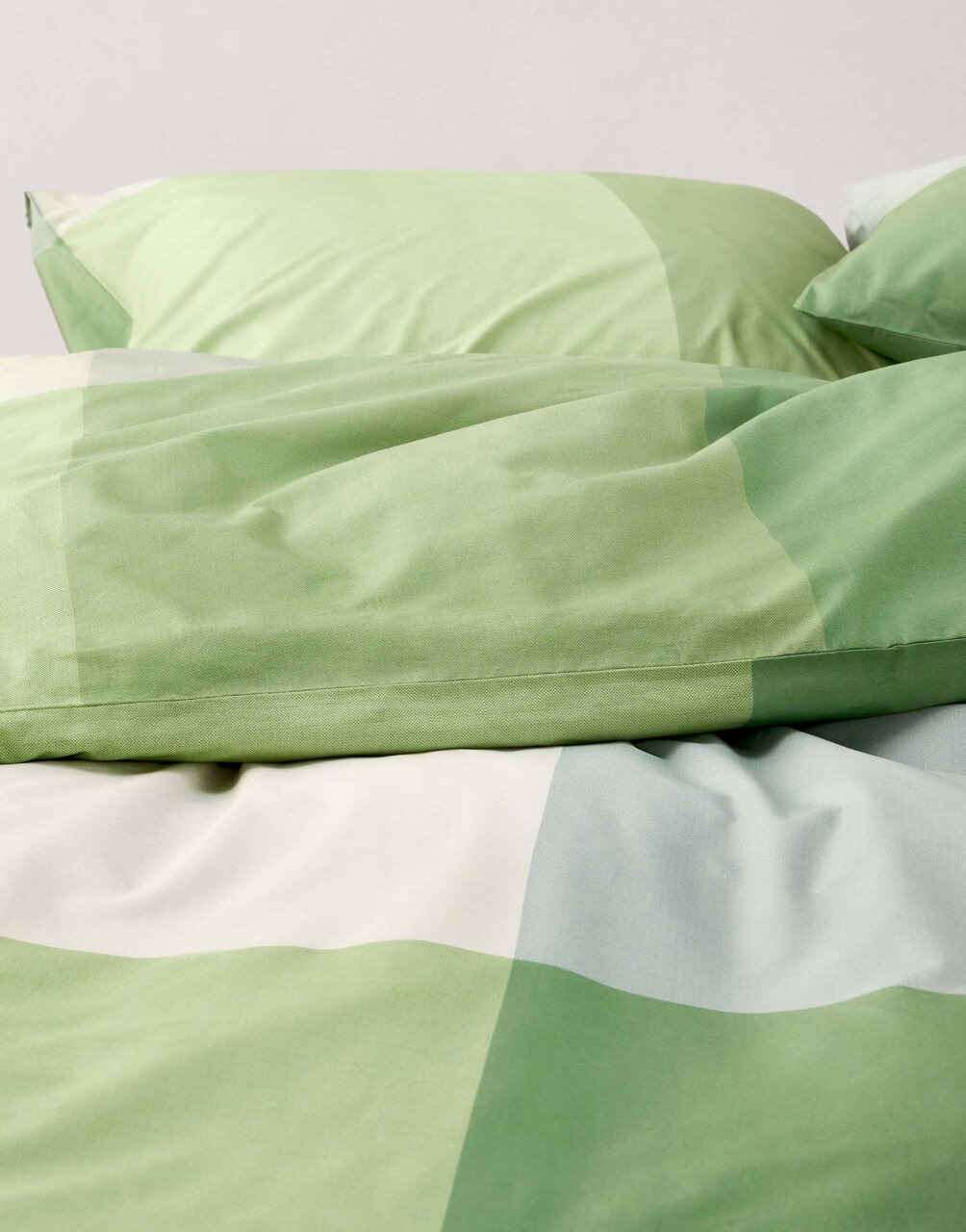 Grüne Bettwäsche mit geometrischem Muster, Nahaufnahme von oben