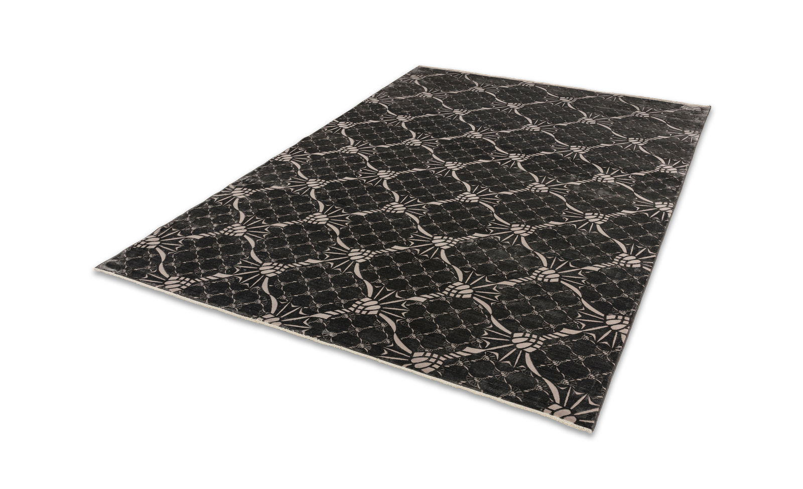 JOOP! CORNFLOWER DOUBLE Graphit Schwarzer Teppich mit stilisiertem Kornblumenmuster, perspektivisch von der Seite fotografiert.