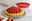 Silikon-Obstkuchenform in Rot, 28 cm, mit einem gebackenen Obstkuchen mit Erdbeeren im Vordergrund, seitliche Perspektive