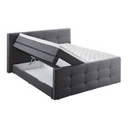 Graues Boxspringbett mit hochgeklappter Matratze und sichtbarem Stauraum, seitliche Perspektive