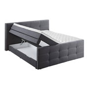 Graues Boxspringbett mit hochgeklappter Matratze und sichtbarem Stauraum, seitliche Perspektive