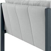 Achterkant van een loungebank met armleuning aan de rechterkant, grijze stoffen bekleding en een donker frame.