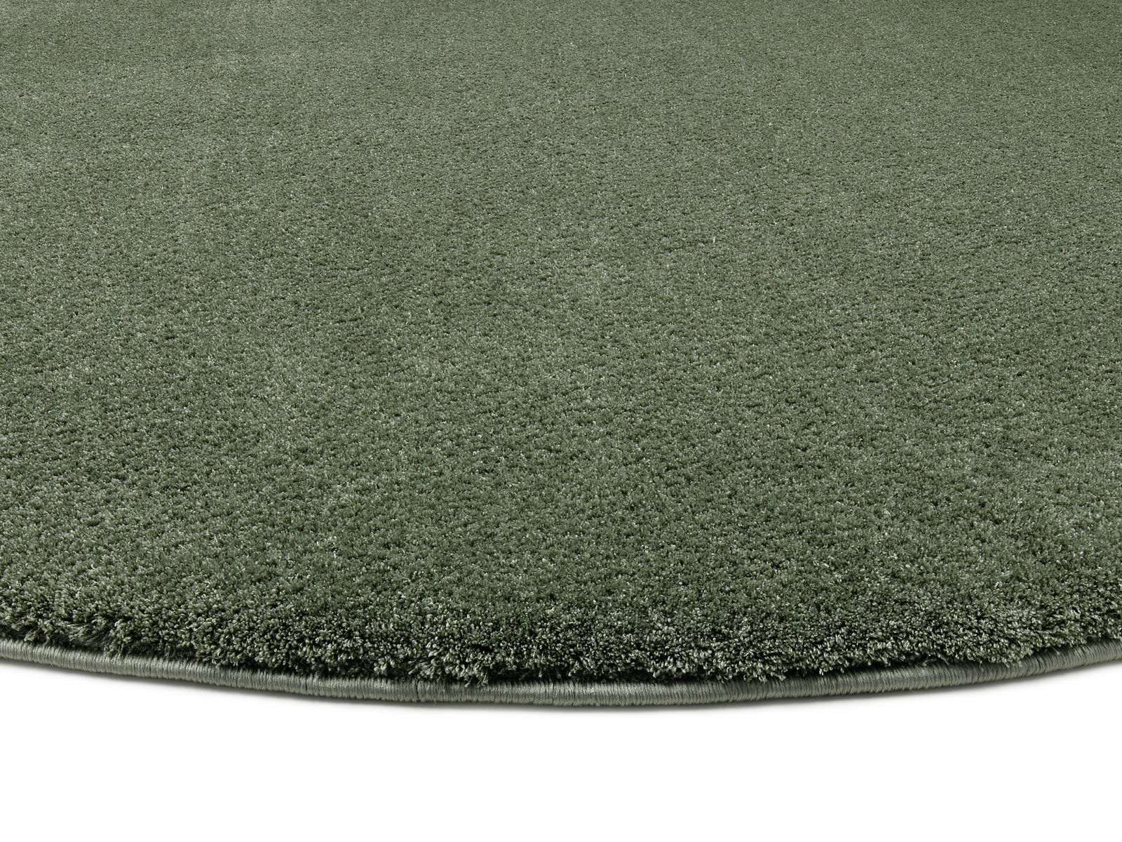 Runder, grüner Teppich mit weicher Oberfläche, Nahaufnahme aus seitlicher Perspektive