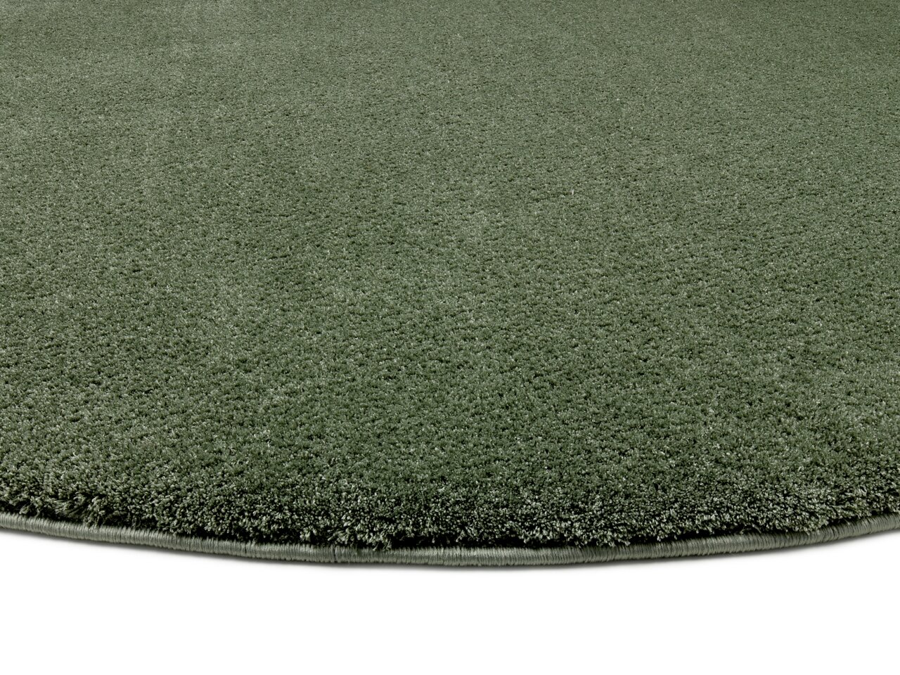 Runder, grüner Teppich mit weicher Oberfläche, Nahaufnahme aus seitlicher Perspektive