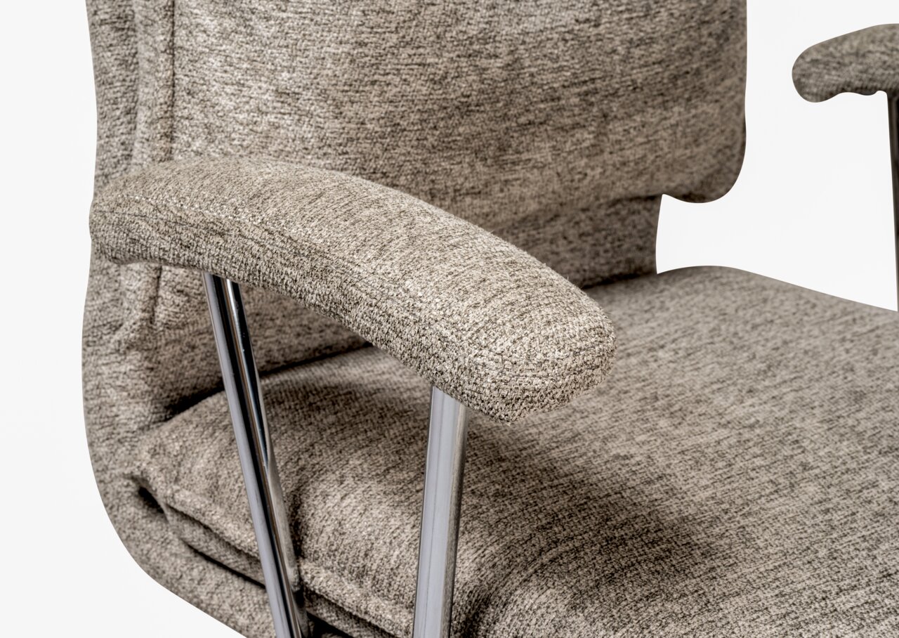 Nahaufnahme eines grauen Home Office Drehstuhls mit gepolsterten Armlehnen und verchromten Metallbeinen, seitliche Perspektive.