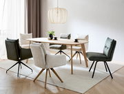 Moderner Esstisch aus Holz mit verschiedenen gepolsterten Stühlen in einem hellen Raum, seitliche Perspektive.