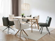 Moderner Esstisch aus Holz mit verschiedenen gepolsterten Stühlen in einem hellen Raum, seitliche Perspektive.