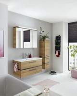 Moderne Badkombination in Holzoptik mit Waschtisch, Spiegelschrank und Hochschrank, seitliche Perspektive