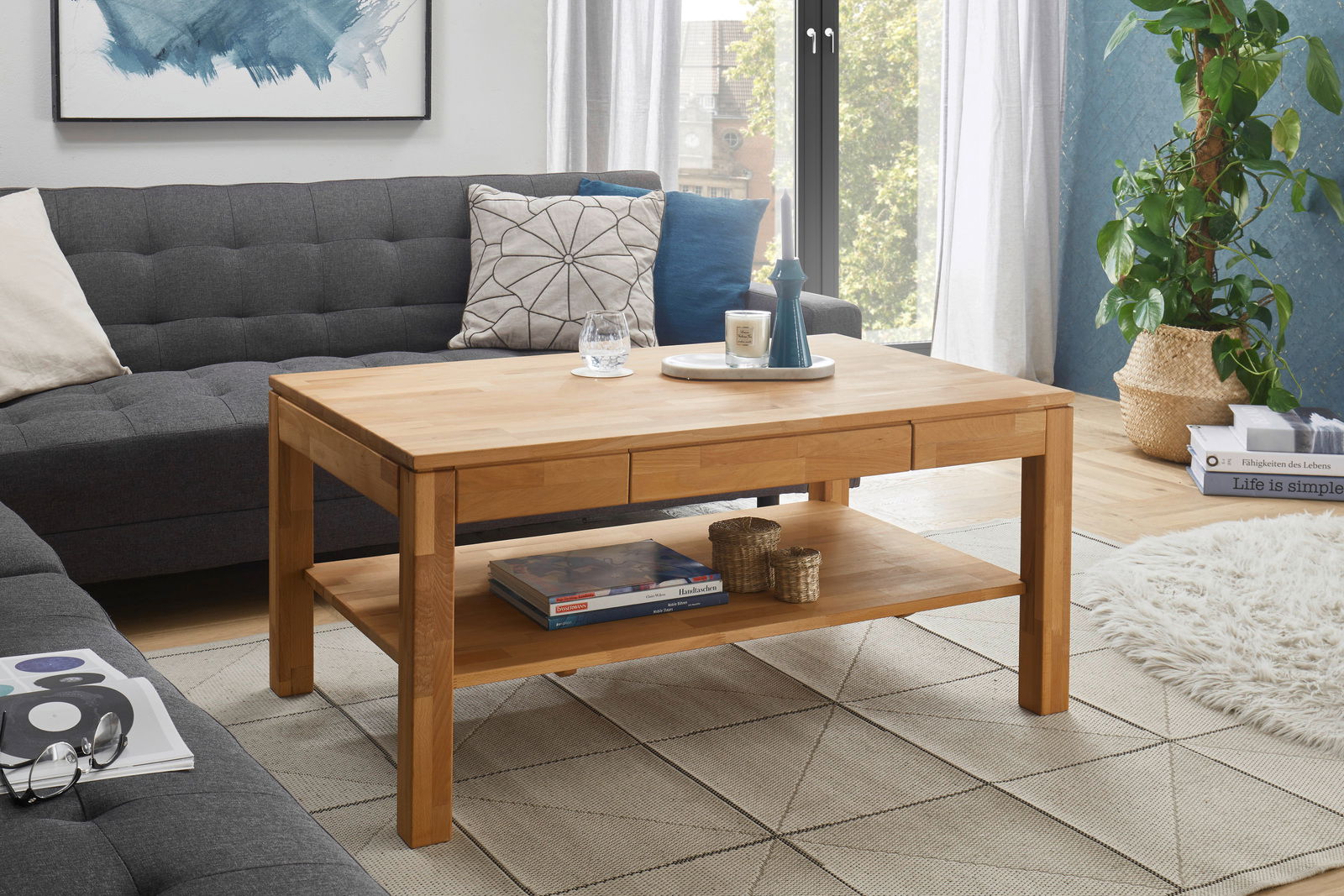 Holz-Couchtisch in einem modernen Wohnzimmer, frontal fotografiert, mit Dekorationen und einem Regal darunter.