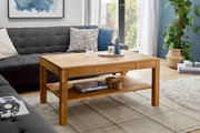 Holz-Couchtisch in einem modernen Wohnzimmer, frontal fotografiert, mit Dekorationen und einem Regal darunter.