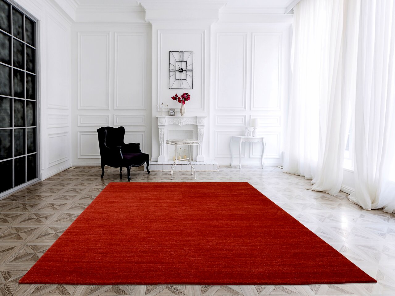 Roter Wollteppich in einem eleganten, hellen Raum mit weißen Wänden und großen Fenstern, aus der Vogelperspektive betrachtet.