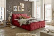 Rotes Boxspringbett in einem modernen Schlafzimmer, seitliche Perspektive