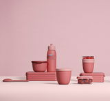 Verschiedene rosa Behälter und Flaschen in einer stilvollen Anordnung, seitliche Perspektive