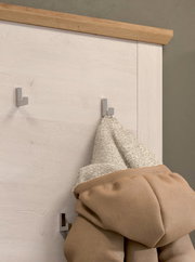 Nahaufnahme einer Garderobenkombination mit Holzelementen und mehreren Haken, an denen Kleidung hängt.