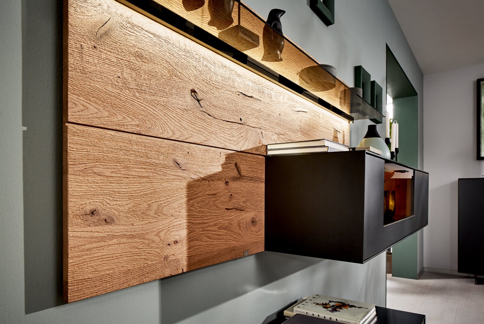 Moderne wandcombinatie met houten bekleding en zwarte kasten, zijaanzicht