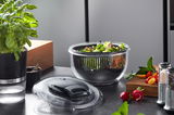 Salatschleuder PULLIT mit frischem Salat, abgebildet aus einer seitlichen Perspektive auf einer Küchenarbeitsplatte.