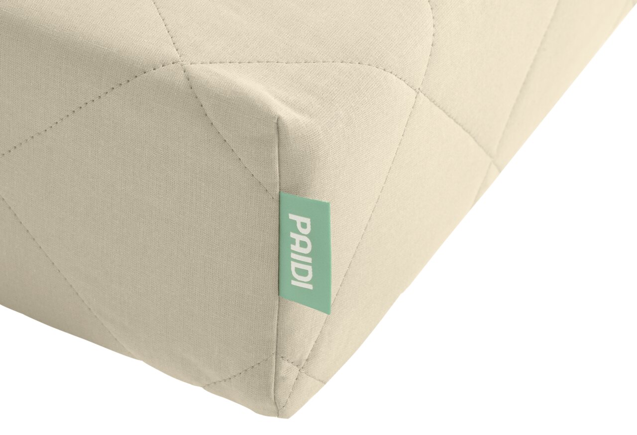 Een hoek van een matras van koudschuim met meerdere zones, voorzien van een groen label met het merk, gezien vanuit een schuin bovenaanzicht.