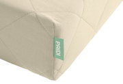Een hoek van een matras van koudschuim met meerdere zones, voorzien van een groen label met het merk, gezien vanuit een schuin bovenaanzicht.