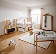Kinderzimmer mit Hausbett, Kleiderschrank, Bücherregal und Schreibtisch in heller, moderner Einrichtung, seitliche Perspektive