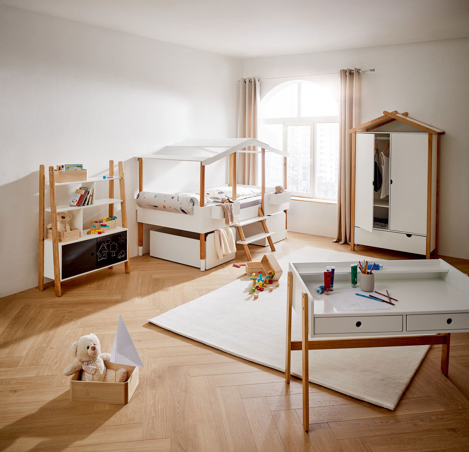 Kinderzimmer mit Hausbett, Kleiderschrank, Bücherregal und Schreibtisch in heller, moderner Einrichtung, seitliche Perspektive
