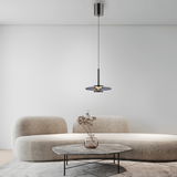 Moderne Pendelleuchte PURE Vitrum in einem stilvollen Wohnzimmer, von der Seite betrachtet, mit einem eleganten Sofa und einem Couchtisch im Hintergrund.