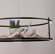 Moderne LED-hanglamp met een zwart frame, versierd met hout en paarse bloemen, gezien vanaf de zijkant.