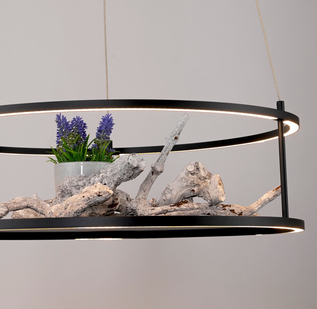 Moderne LED-hanglamp met een zwart frame, versierd met hout en paarse bloemen, gezien vanaf de zijkant.