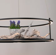 Moderne LED-Pendelleuchte mit schwarzem Rahmen, dekoriert mit Holz und lila Blumen, seitliche Perspektive.