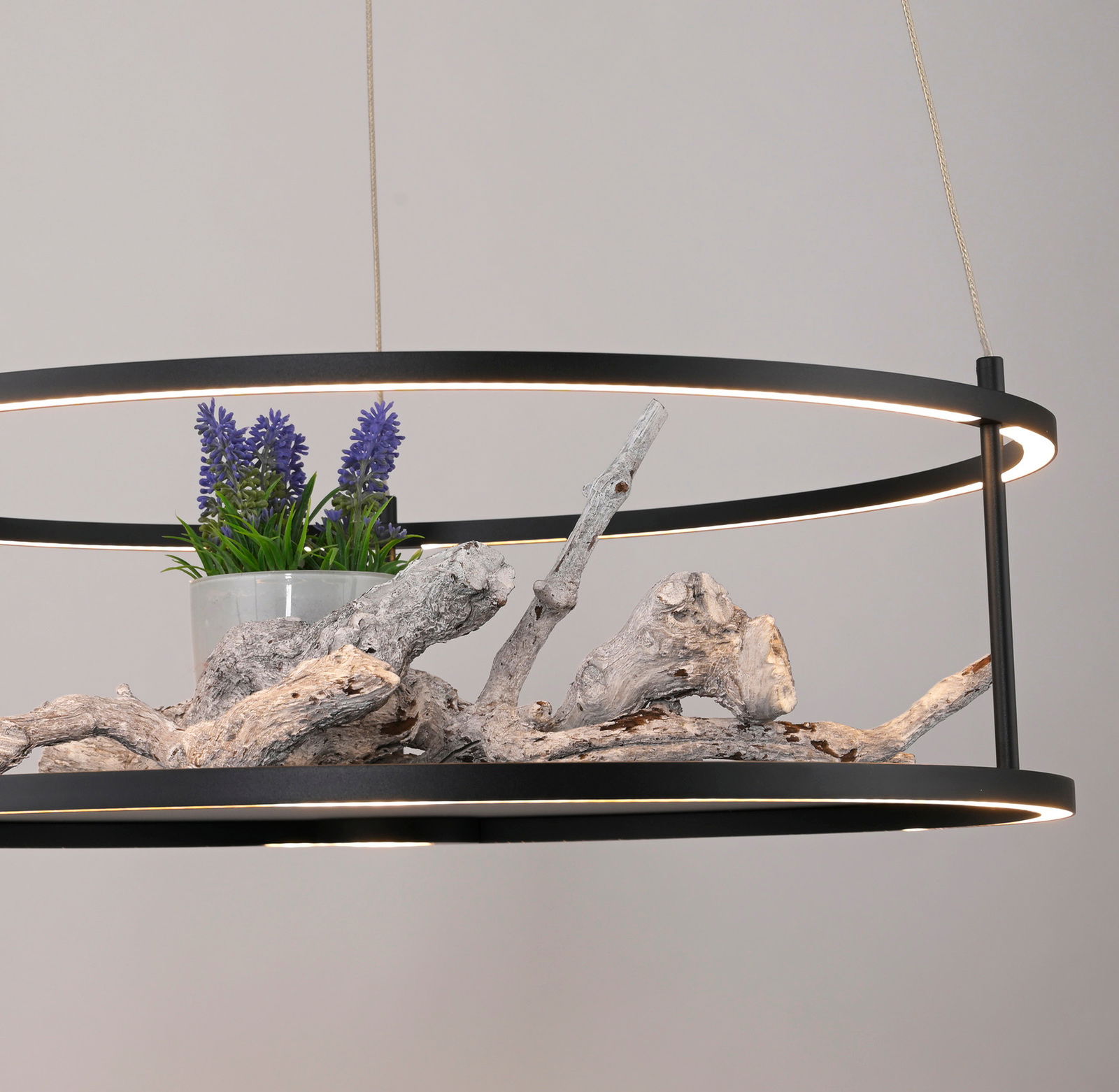 Moderne LED-Pendelleuchte mit schwarzem Rahmen, dekoriert mit Holz und lila Blumen, seitliche Perspektive.