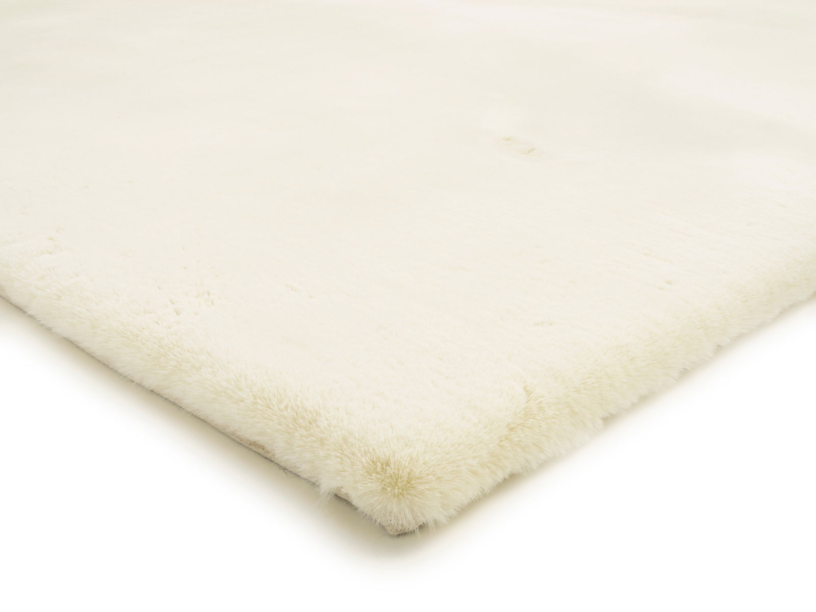 Nahaufnahme eines weißen Fellteppichs aus der Seitenperspektive, der die weiche Textur und die flauschige Oberfläche zeigt.