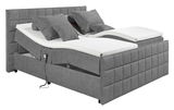 Graues Polsterbett mit verstellbaren Matratzen und mehreren Kissen, seitliche Perspektive