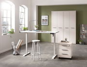 Moderner höhenverstellbarer Schreibtisch in einem hellen Büro mit Blick auf Fenster und Schränke im Hintergrund.