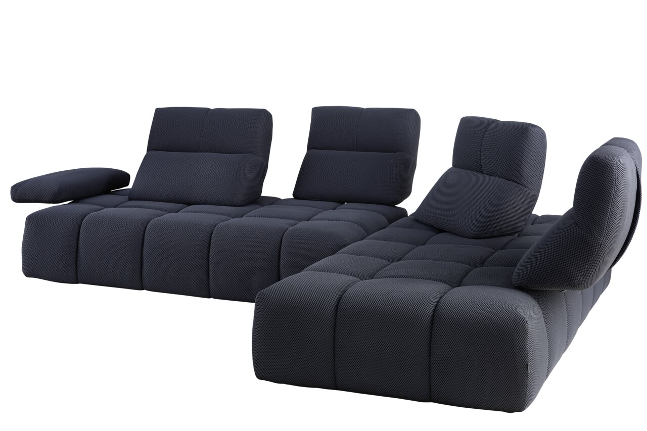 Moderne Eckgarnitur in dunklem Stoff, perspektivisch von vorne links fotografiert.