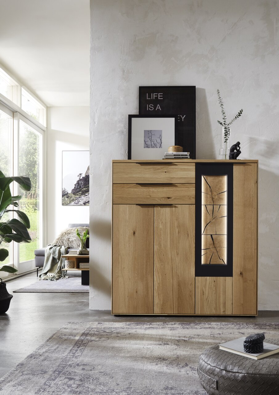 Wöstmann Markenmöbel Hoog dressoir WK 1910 Modernes Highboard aus Holz mit dekorativem Glaseinsatz, frontal fotografiert in einem hellen Wohnzimmer.
