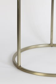 Nahaufnahme eines goldfarbenen Metallgestells eines Beistelltisches, von der Seite betrachtet.