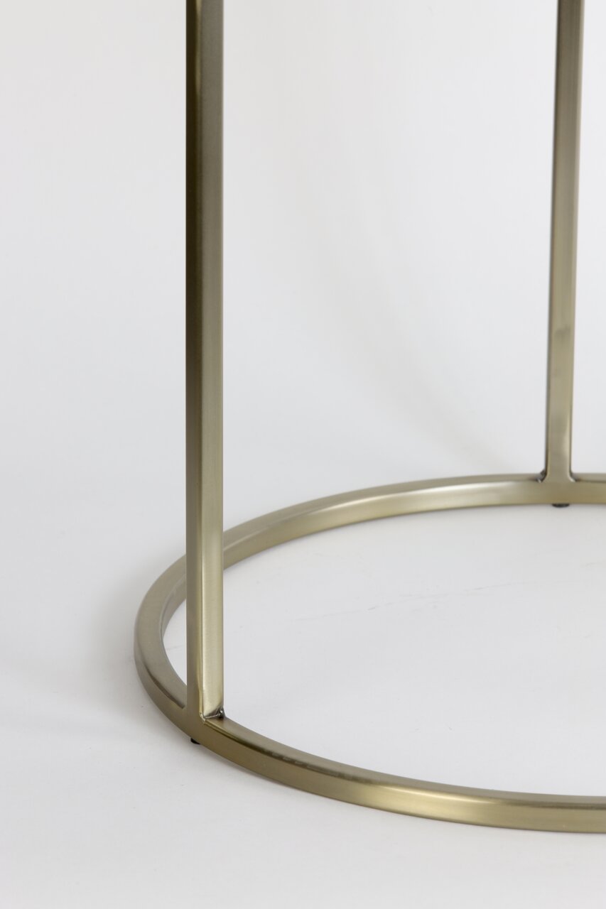 Close-up van het goudkleurige metalen frame van een bijzettafeltje, gezien vanaf de zijkant.