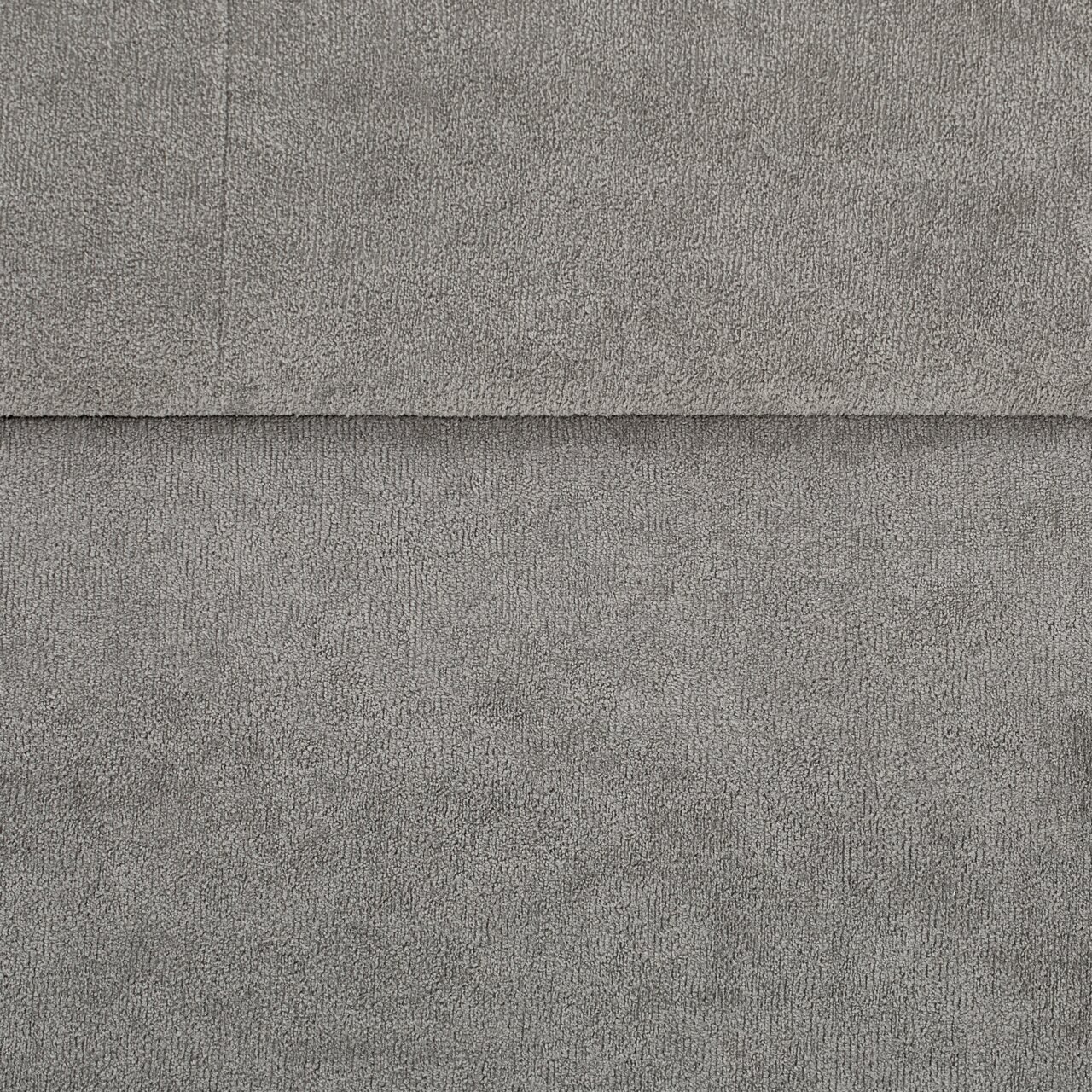 Nahaufnahme einer grauen Hockerbank mit Stauraum, Textur des Stoffes sichtbar.