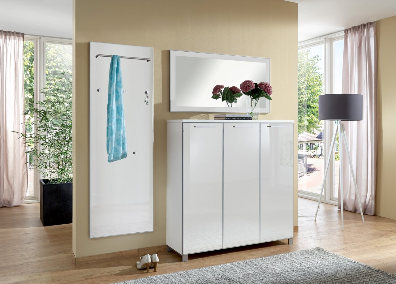 Garderoben-Set 3-tlg. in modernem Design, bestehend aus einem weißen Schrank mit drei Türen, einem Wandspiegel und einer Garderobenleiste mit Haken und Stange, seitliche Perspektive.