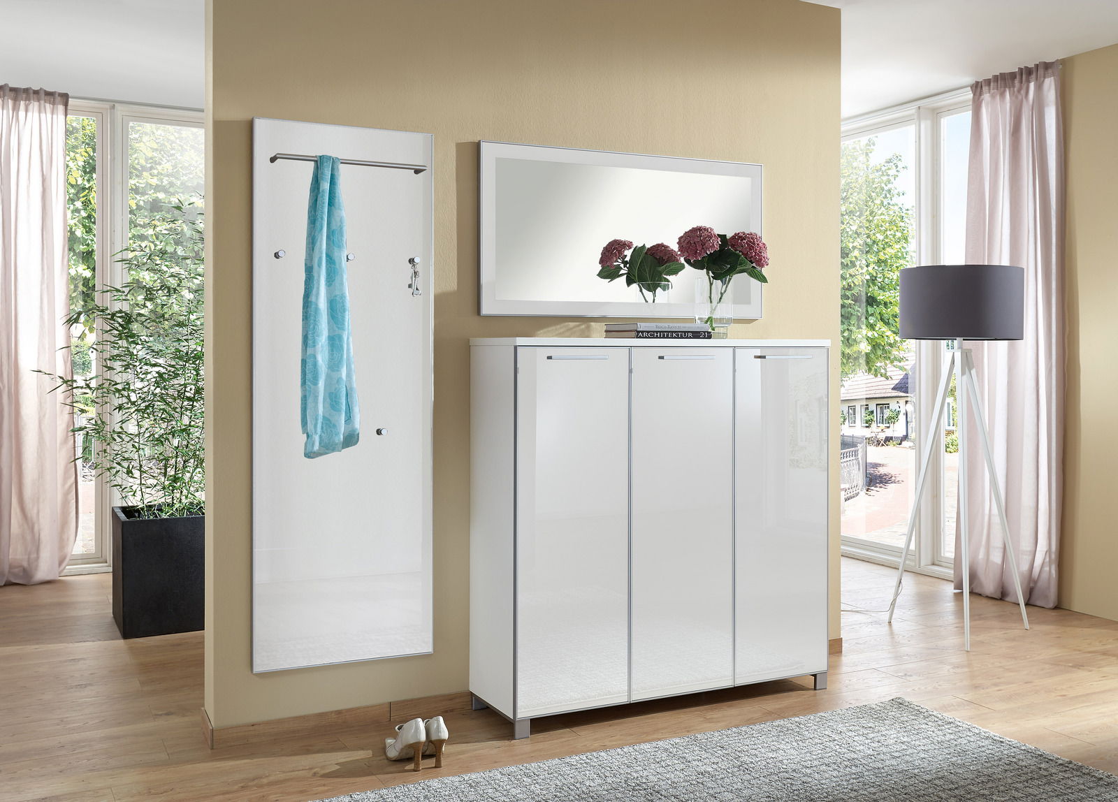 Garderoben-Set 3-tlg. in modernem Design, bestehend aus einem weißen Schrank mit drei Türen, einem Wandspiegel und einer Garderobenleiste mit Haken und Stange, seitliche Perspektive.