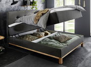 Boxspringbett mit hochgeklappter Matratze und Stauraum darunter, seitliche Perspektive