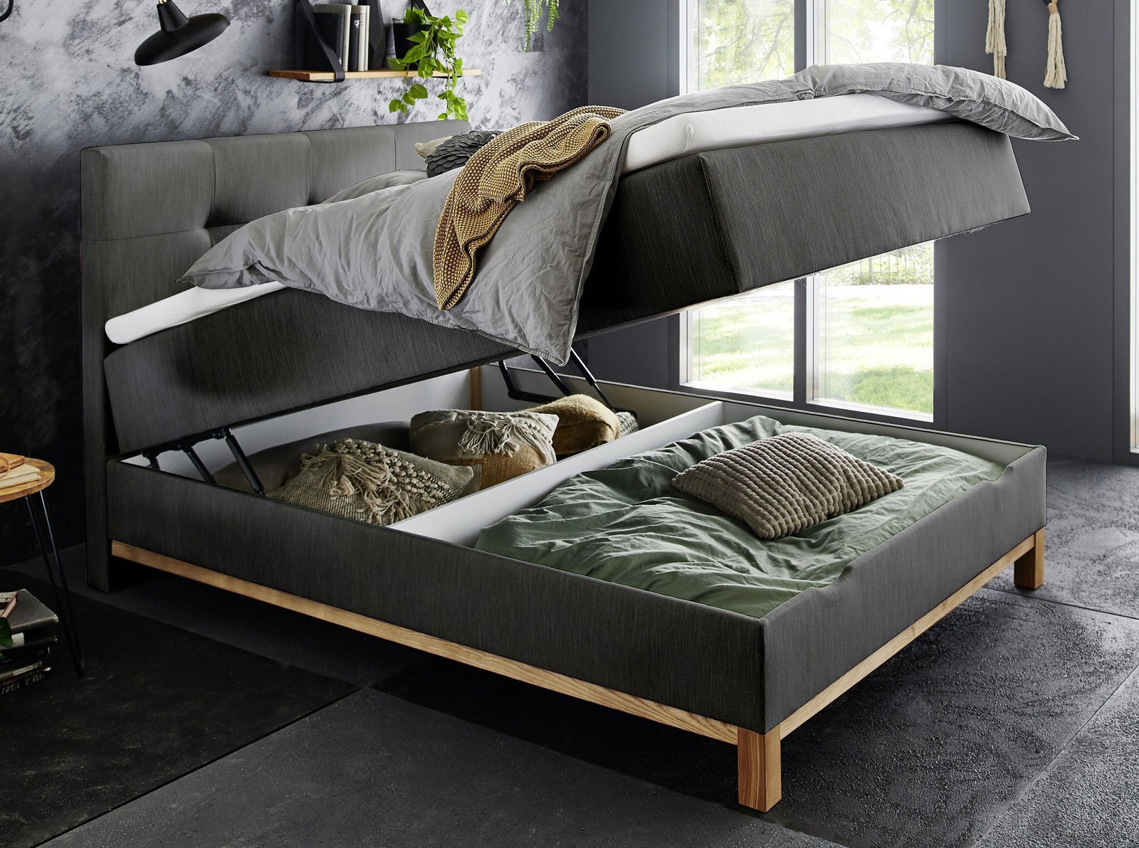 Boxspringbett mit hochgeklappter Matratze und Stauraum darunter, seitliche Perspektive