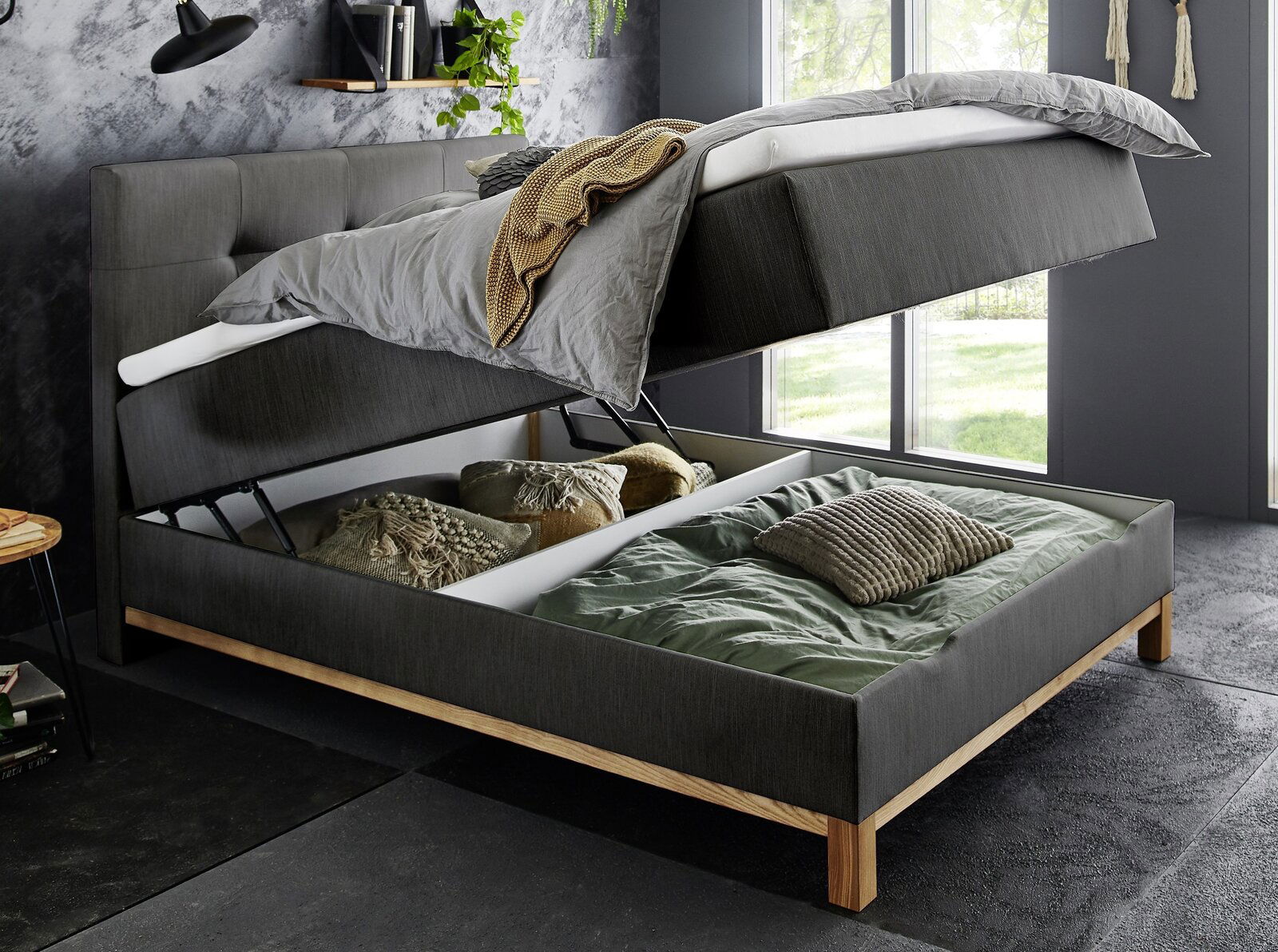 Boxspringbett mit hochgeklappter Matratze und Stauraum darunter, seitliche Perspektive