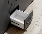 Geöffnete Schublade eines modernen, grauen Sideboards aus der Vogelperspektive.