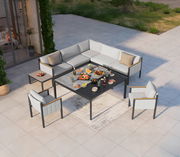 Lounge-Set auf einer Terrasse aus der Vogelperspektive, bestehend aus einem Ecksofa, einem Gartentisch und zwei Sesseln, dekoriert mit Speisen und Getränken.