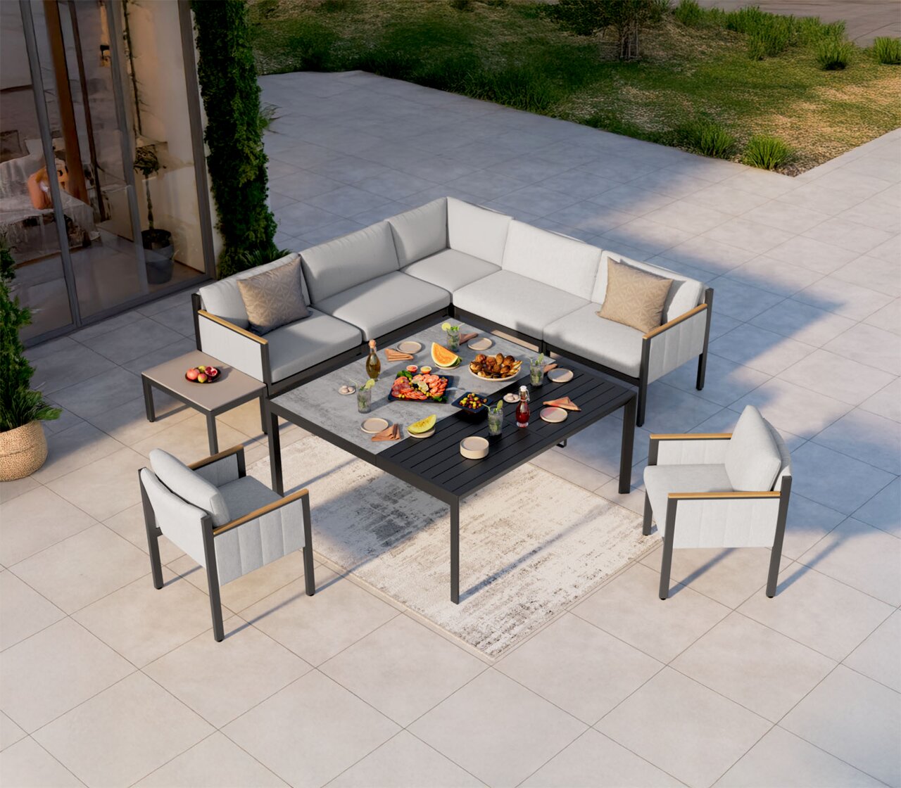 Lounge-Set auf einer Terrasse aus der Vogelperspektive, bestehend aus einem Ecksofa, einem Gartentisch und zwei Sesseln, dekoriert mit Speisen und Getränken.