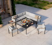 Lounge-Set auf einer Terrasse aus der Vogelperspektive, bestehend aus einem Ecksofa, einem Gartentisch und zwei Sesseln, dekoriert mit Speisen und Getränken.