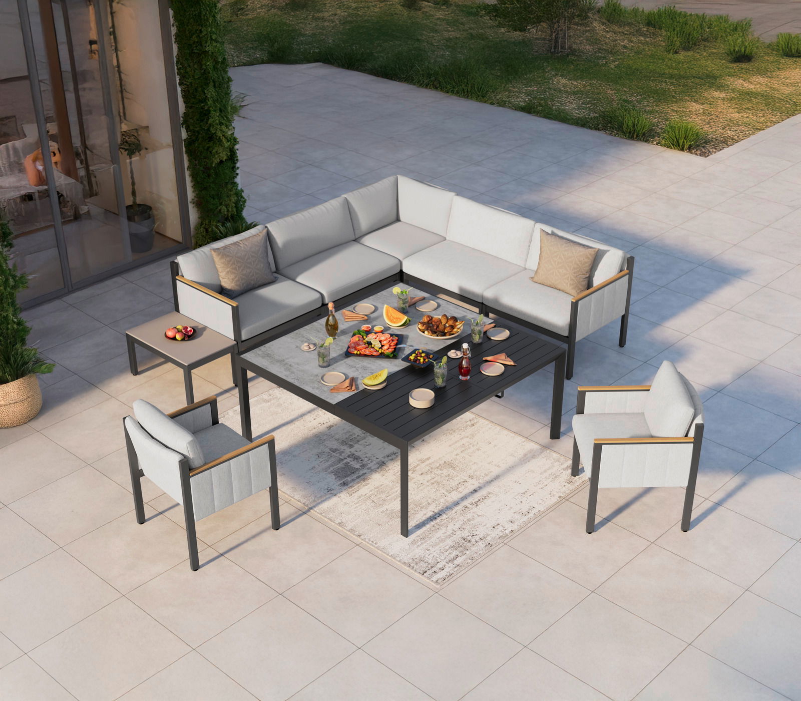 Lounge-Set auf einer Terrasse aus der Vogelperspektive, bestehend aus einem Ecksofa, einem Gartentisch und zwei Sesseln, dekoriert mit Speisen und Getränken.