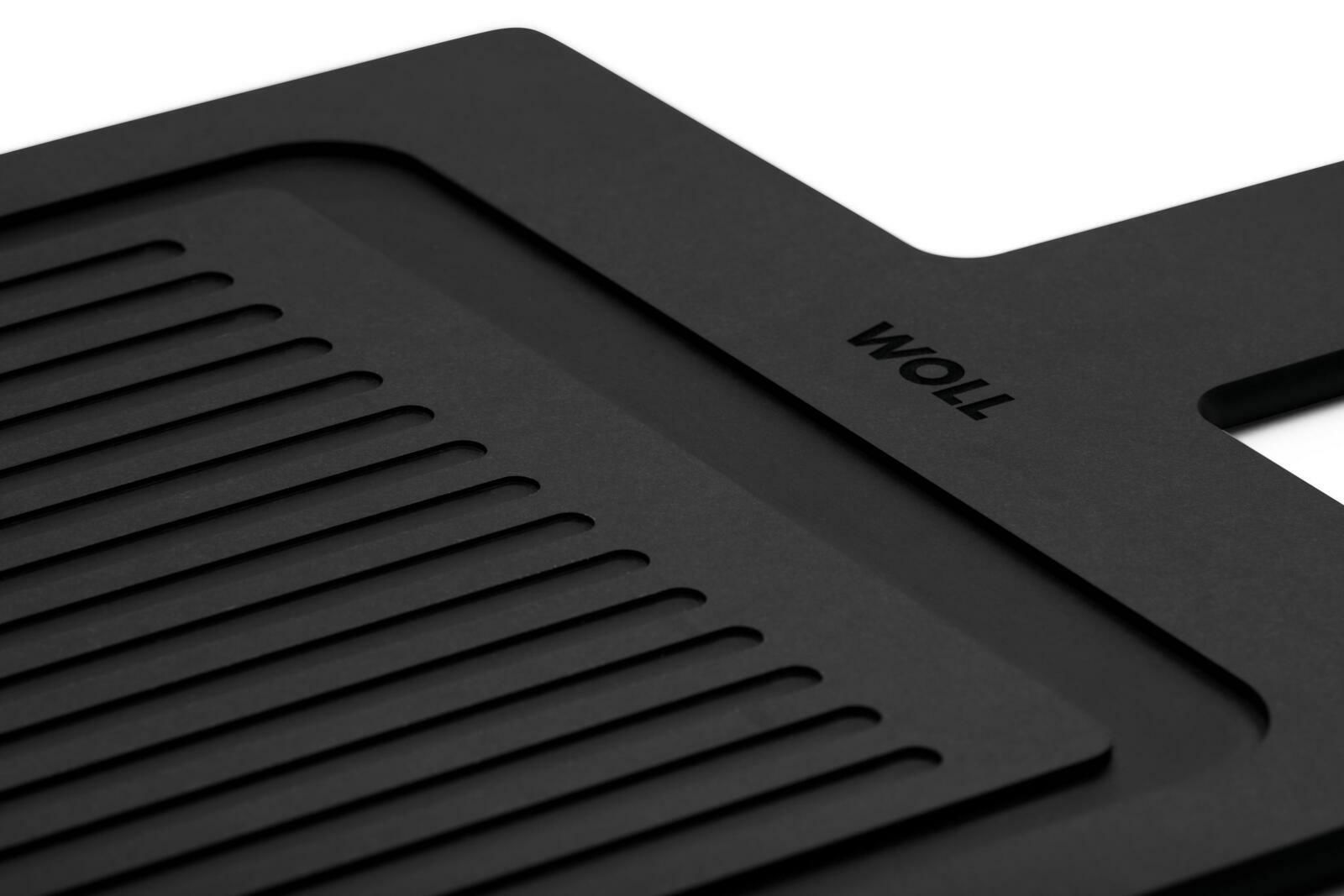 Nahaufnahme eines schwarzen Schneidebretts mit Rillen und Griff, seitliche Perspektive