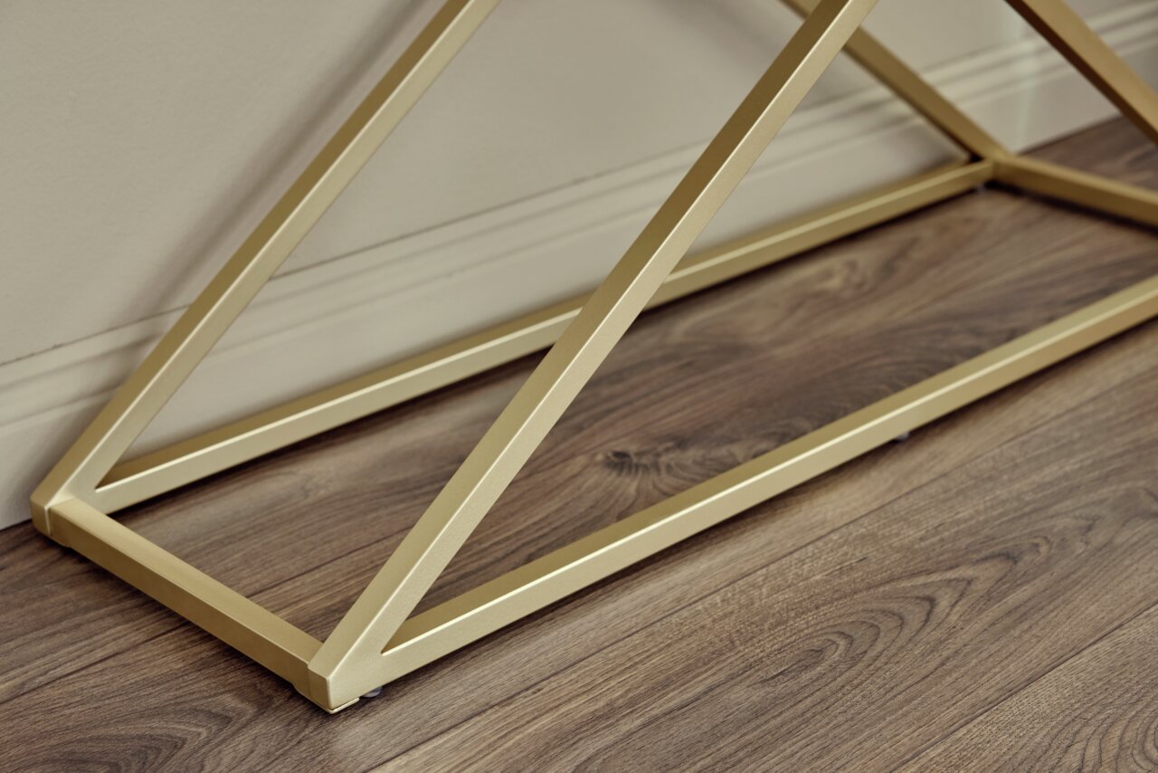 Nahaufnahme eines goldenen Metallgestells einer Konsole auf einem Holzboden, seitliche Perspektive